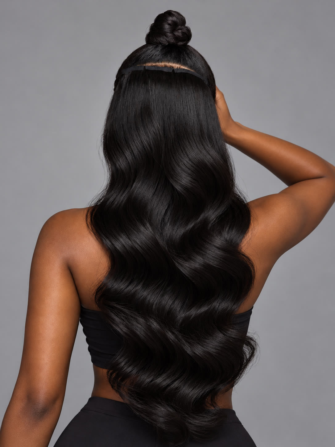 Model wearing body wave tape-in extensions, back view